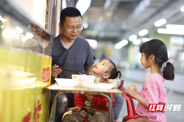 华夏农贸市场商户叶伟和女儿一起吃午饭。