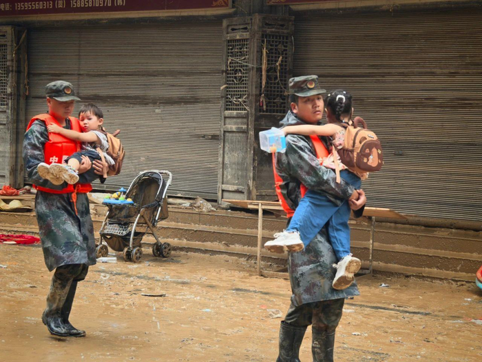 救援人员帮助儿童摛离洪区（图源：榕江发布）