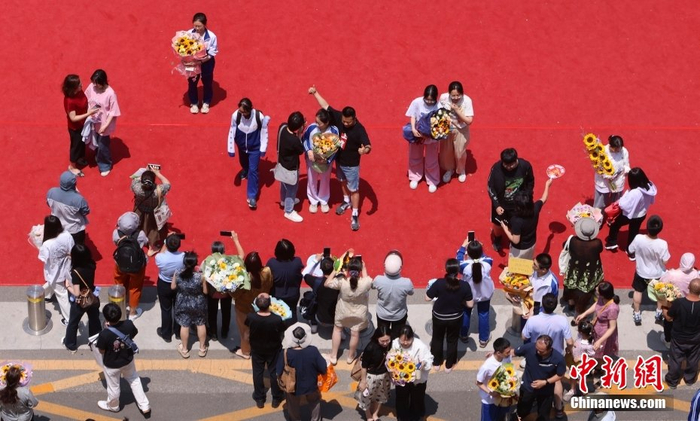 资料图：6月10日，北京市首师大附中通州校区考点外，考生走出考点接受亲人的祝福。中新社记者 杨可佳 摄