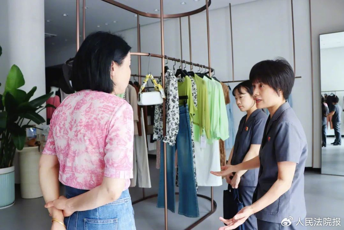 图为法官前往被告经营的服装店进行现场勘察。