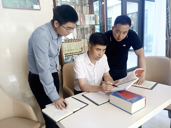 图为张凯（中）正在与同事们研读纪律条款。张楠 摄