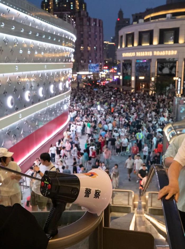 通往兴业太古汇的自动扶梯上方，一个警方喇叭反复提醒上行游客注意安全。图片来源：新民晚报