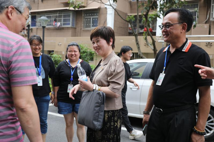     2021年6月24日，在修缮一新的普陀区桃浦镇莲花公寓，梁慧丽（中）正与居民交流。（李茂君 摄）