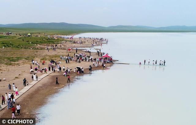 ↑2025年6月28日，游客在内蒙古锡林郭勒盟太仆寺旗白音查干湖边游玩。（无人机照片）CICPHOTO/孙慧军 摄