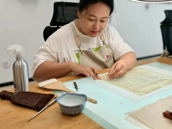 古籍修复师谭依玲正在修复书叶