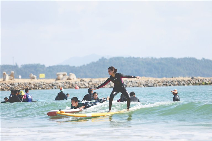 游客在万宁日月湾体验冲浪乐趣。海南日报全媒体记者 周达延 摄