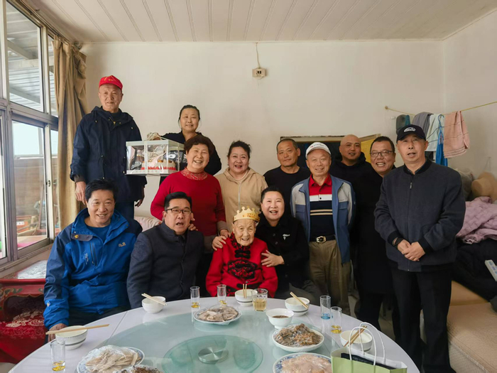 张立英（一排左四）为村里老人庆生。受访者供图