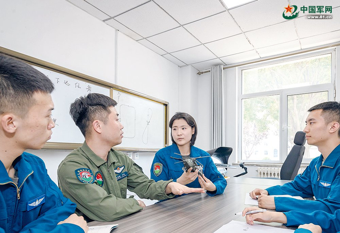 　　飞行技能考核结束后，教官（左二）指导学员进行复盘。