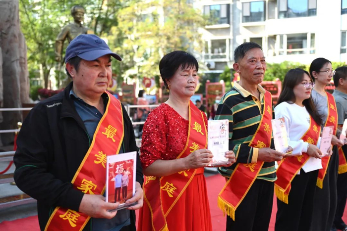 ▲2024年9月25日，居民在长城花园社区广场领社区“最美家庭”奖。新华社记者 毛竹 摄