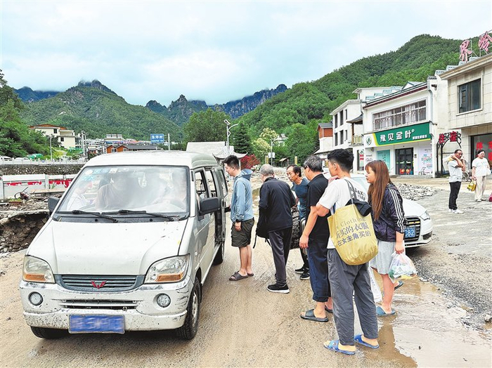 7月1日，西峡县太平镇政府统一调度车辆，将滞留在灾害区域的游客安全转运至镇上安全区域。 杨永青 摄