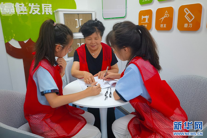 图为张家湾社区志愿者在小区党群服务驿站筹划家庭义卖活动。新华网发