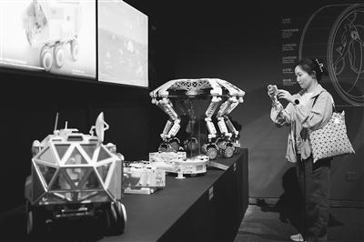 图为观众观看“宇宙考古：时空探索”展览上展示的月面多功能平台及智能火星探测器模型。记者 洪星摄
