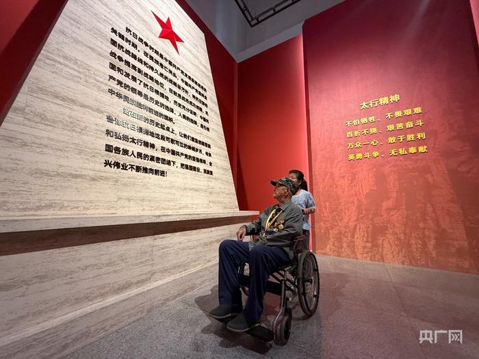 在家人的陪伴下，老人参观了“山河永固”展览（央广网记者 张晋鹏 摄）