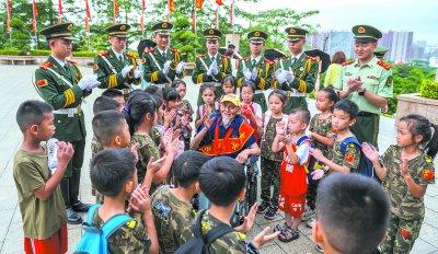 ▲孙洪秀(中)给武警官兵和少先队员讲红色故事。唐明洋/摄