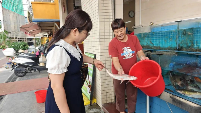 △河鲜酒楼热情迎客，向食客推荐店内的各类河鲜。