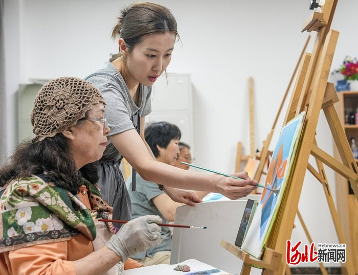 6月19日，石家庄市老年大学丙烯画教师王云婵指导老年学员学习绘画技巧。 河北日报记者 李东宇摄