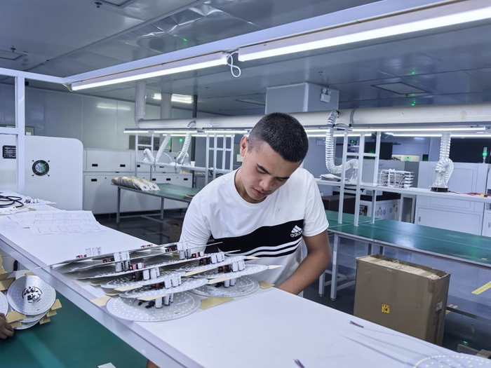 　　6月24日，新疆领航新能源科技发展有限公司的员工正在组装灯具。（新华社记者 顾煜 摄）