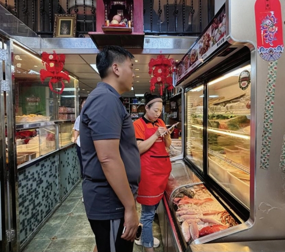 　　图为消费者正在广东美食·潮汕味道店挑选菜品。