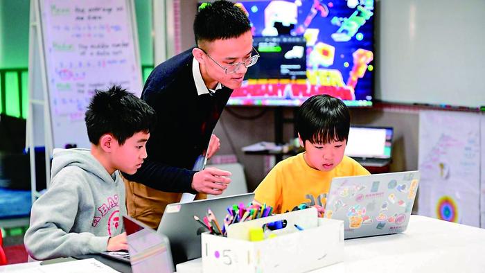 ▲“编程社团”的孩子们在老师的指导下学习编程。