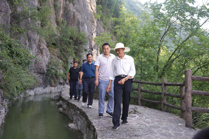 图为守渠人谭祖顺在绝壁天河边讲解。新华社发