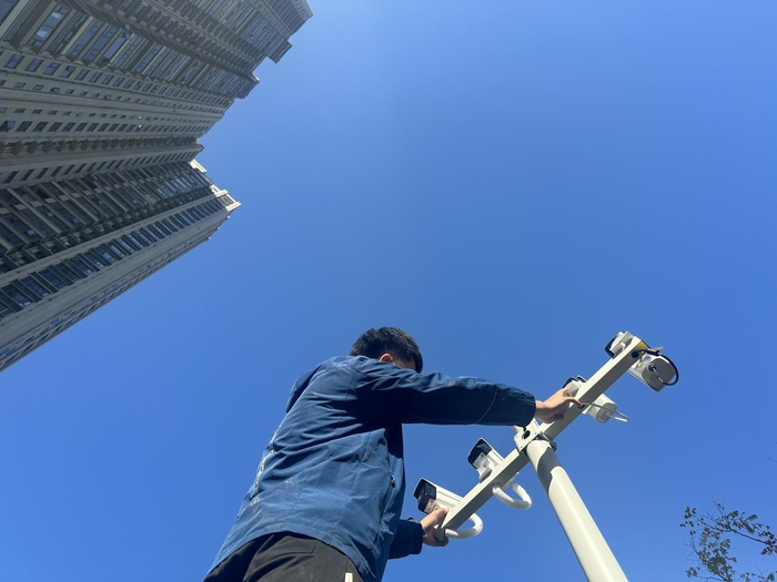 图：工作人员检修高空抛物摄像头