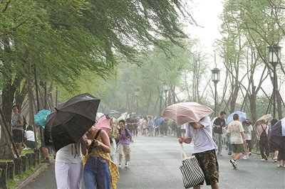 7月8日下午2点左右，西湖上空飘来一团乌云，瞬时狂风大作、暴雨倾盆，令白堤上众多无处藏身的游客措手不及。记者 李忠 摄