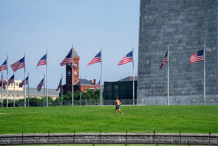 6月23日，在美国首都华盛顿，一名男子在草地上跑步。新华社记者胡友松摄