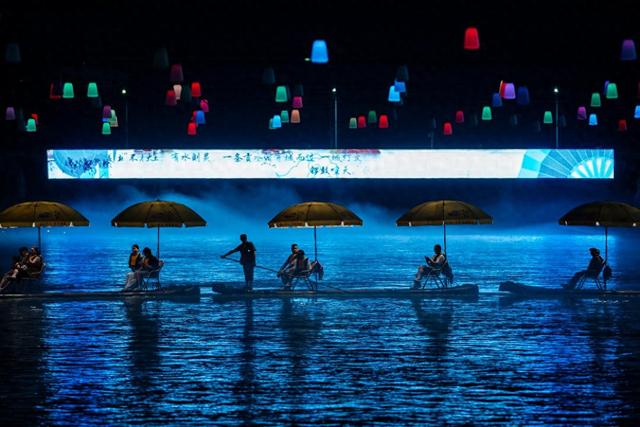 7月9日，游客乘坐“龙游贡水”竹筏在贡水河上赏夜景。 新华社记者 伍志尊 摄