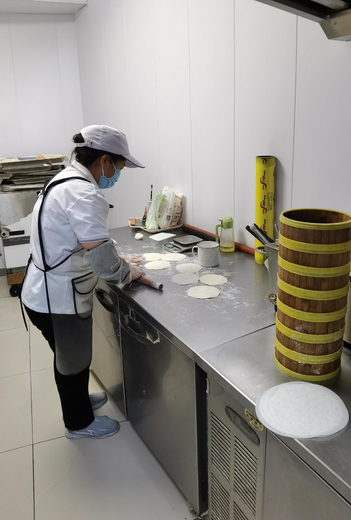 早上5点，北京观澜国际花园助餐食堂的面点师刘大姐在制作包子。桑雪骐/摄