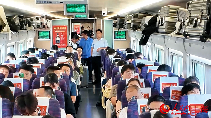 不少乘客没买到坐票，站在车厢接口处。人民网 顾海民摄