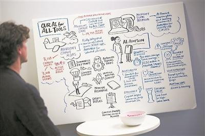 第九届伦敦AI峰会期间，一位参观者在观看展板上的内容，介绍AI在各方面的应用。图片来源：物理学家组织网