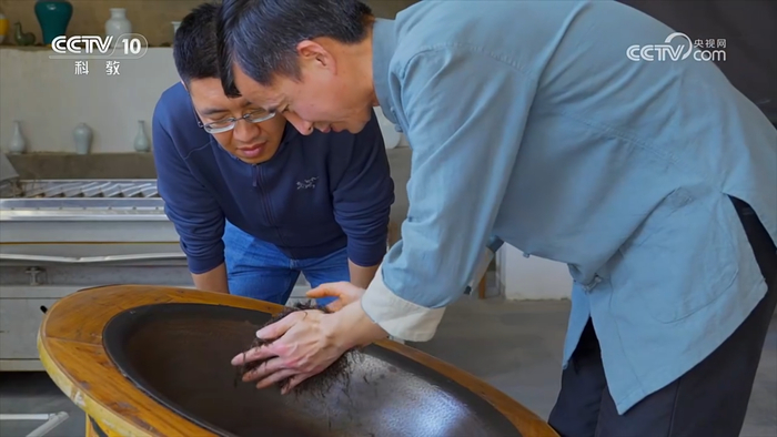 省级浮梁工夫红茶非遗传承人江建鸿正在炒制茶叶（图片来源：纪录片《沿着纬度听中国》第四集“茶之故乡”截图画面）