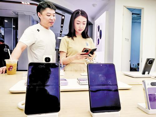     7月7日，消费者在承德一家商场选购手机。本报记者 陈宝云摄
