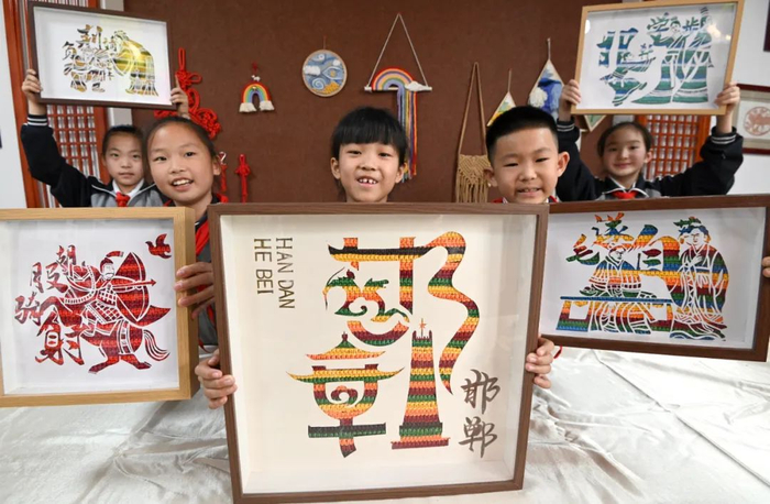 ▲河北省邯郸市复兴区铁路小学的学生展示他们制作的成语绳结工艺品。图片来源：视觉中国