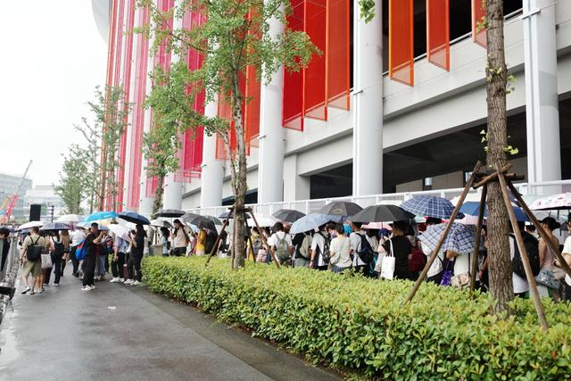 一大早，天空下起小雨，玩家撑着伞等候入场，张熠摄