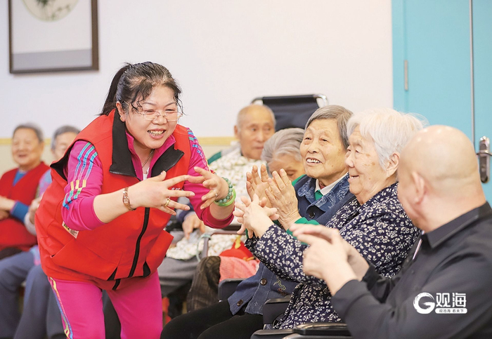 养老机构工作人员带领老人开展趣味活动。