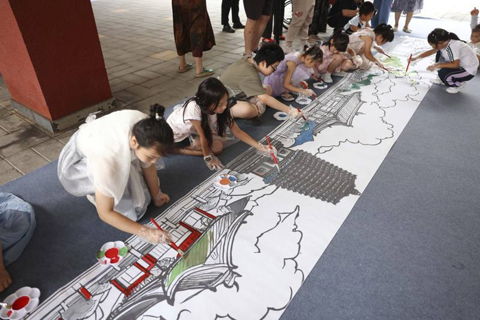 家长与孩子们携手，在10米巨幅画布上共同绘出心中的慈寿寺。新京报记者 浦峰 摄