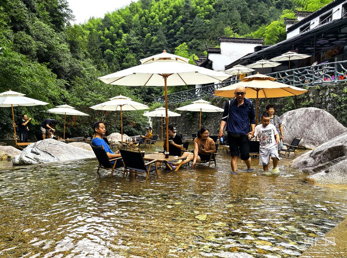 游客在九龙瀑浅水中享受咖啡慢时光（央广网见习记者  刘浩  摄）