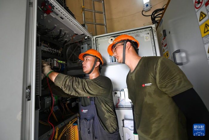 7月10日，在国家能源集团天津龙源新能源有限公司大苏庄风电场，工作人员在风电机组内检查变电设备。新华社记者赵子硕摄