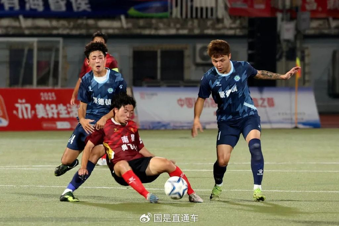 🔹7月12日晚，南昌队球员（红衣）与景德镇队球员（蓝衣）在球场上拼抢。中新社记者 刘占昆 摄