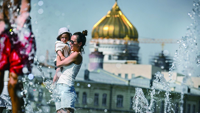     7月11日，在俄罗斯首都莫斯科，人们在喷泉中戏水降温。 新华社发