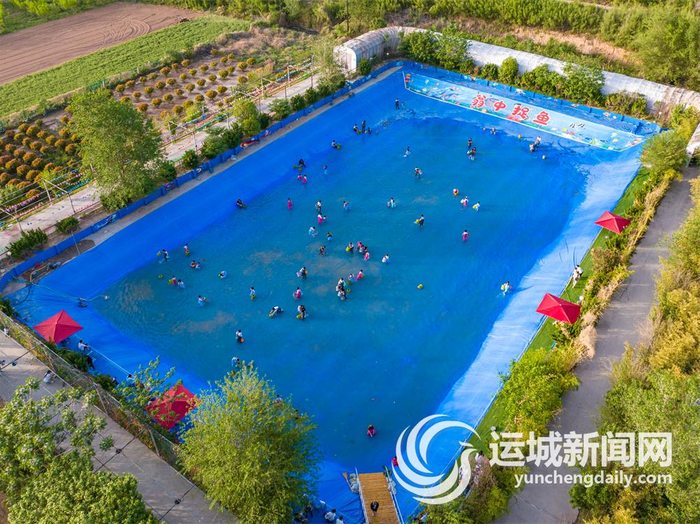 盐湖区东郭镇野趣大自然亲子农场新设“瓮中抓鱼”项目，吸引了众多游客。 记者 陈方斌 摄