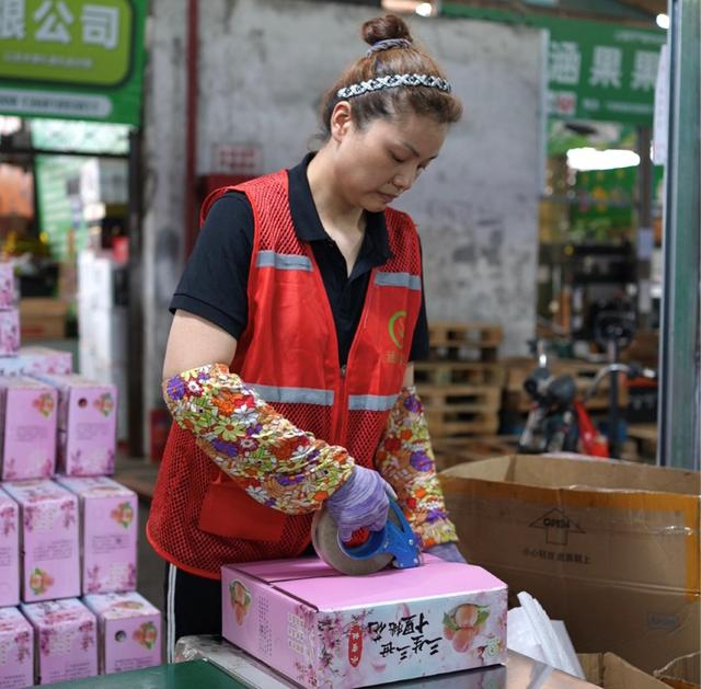 上海农产品批发市场内，员工们正打包着当日鲜果。周良波丨摄
