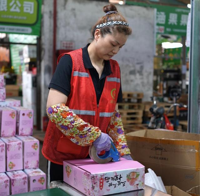 上海农产品批发市场内，员工们正打包着当日鲜果。周良波丨摄