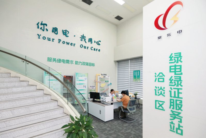 国网江苏常州供电公司员工在绿电绿证服务站协助客户办理绿电交易手续。