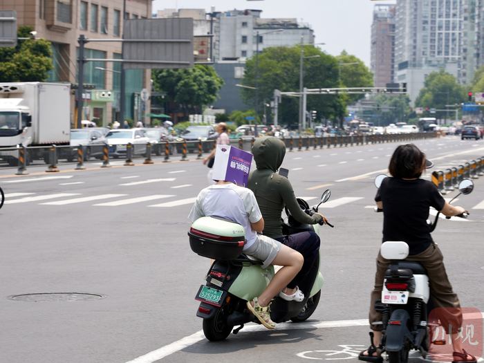 成都市民遮阳出行。
