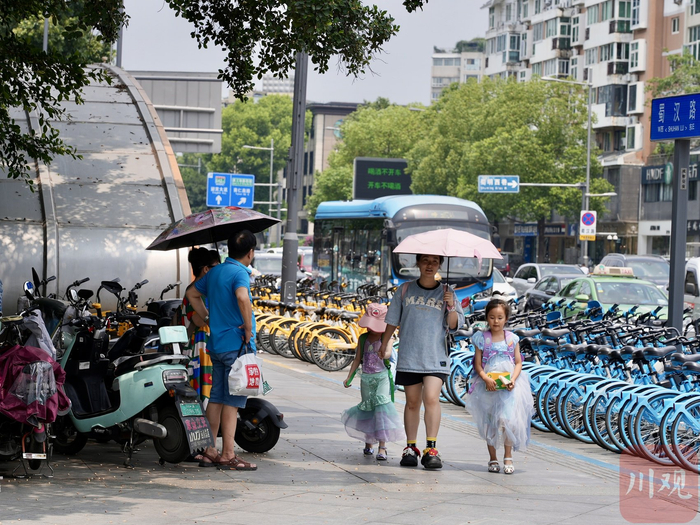 成都市民遮阳出行。