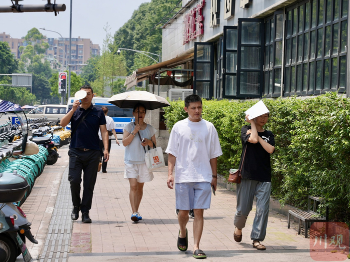 成都市民遮阳出行。