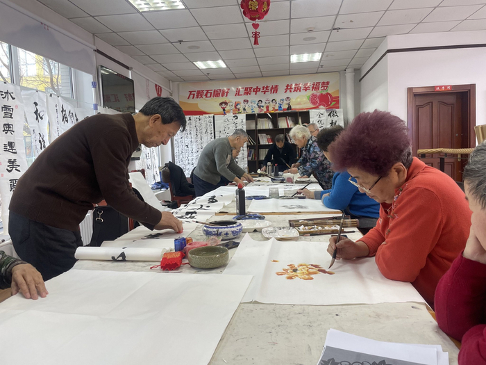 文化家园社区的老年人聚在一起画画、写书法