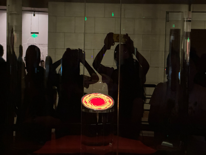 游客驻足在太阳神鸟金饰的展柜前观看留影。陆橙/摄